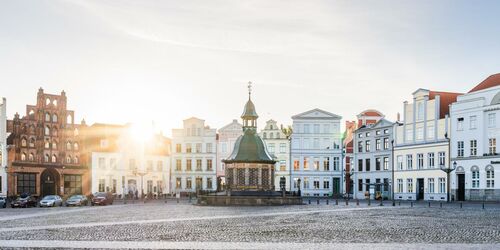 Marktplatz mit Wasserkunst in der Hansestadt Wismar zum Sonnenaufgang, Foto: TMV/Gross